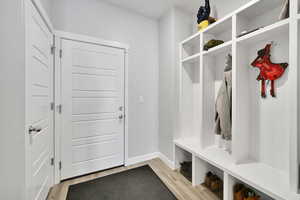 Mudroom with light wood-style flooring and baseboards