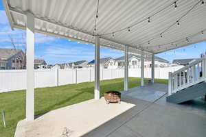 View of patio with a residential view, a fire pit, and a fenced backyard