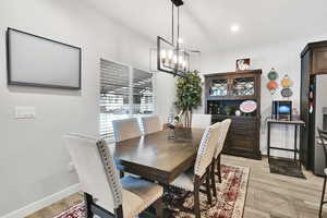 Dining area with light wood-style flooring, recessed lighting, baseboards, and a chandelier