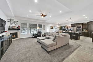 Living room featuring recessed lighting, a tray ceiling, and a tile fireplace