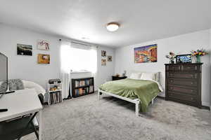 Bedroom with visible vents, a textured ceiling, and carpet floors