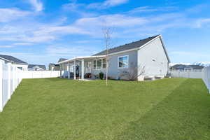 Back of property featuring a fenced backyard, stucco siding, a patio, and a yard