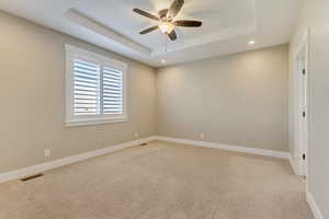 Main floor primary bedroom (1) with a tray ceiling.