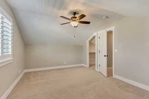 Upstairs bedroom (4) with vaulted ceilings and a walk in closet.