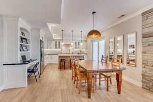 Downstairs In-law suite dining space crown molding, recessed lighting, and light wood-style tile floor.