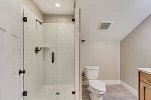 Upstairs bathroom with vanity, toilet, and a shower stall.