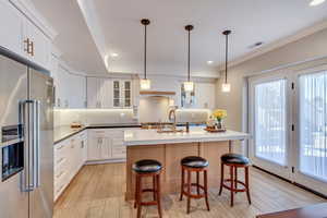 Downstairs In-law suite Kitchen with a wealth of natural light, high end cabinetry, and light wood-style tile floor.