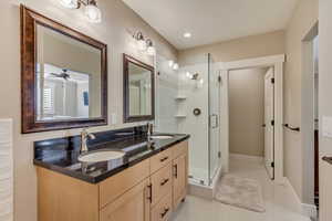 Downstairs In-law suite primary bathroom with double vanity, a stall shower, dual vanity.