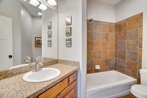 Bathroom with vanity, shower / tub combination, and toilet