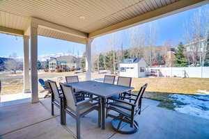 View of patio / terrace featuring a fenced backyard, a storage shed, outdoor dining area, and an outdoor structure