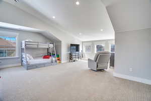 Bedroom with vaulted ceiling, carpet flooring, and baseboards