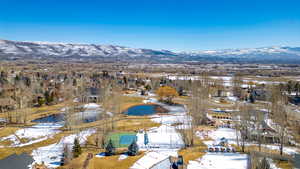 Snowy aerial view with a mountain view and a residential view