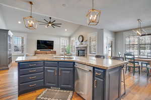 Kitchen with a sink, plenty of natural light, stainless steel dishwasher, and open floor plan