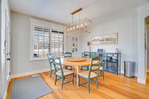 Dining area with a chandelier, baseboards, and wood finished floors