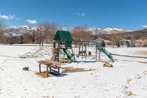 Snow covered playground with a mountain view and playground community