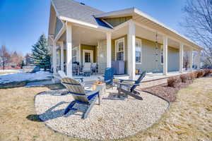 Rear view of house with a patio, board and batten siding, a shingled roof, and an outdoor fire pit