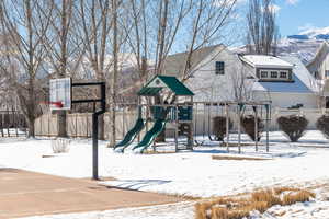 Snow covered playground with playground community and fence