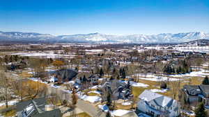 Snowy aerial view with a mountain view and a residential view