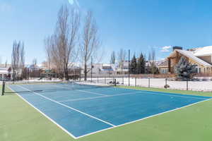 View of sport court featuring playground community and fence