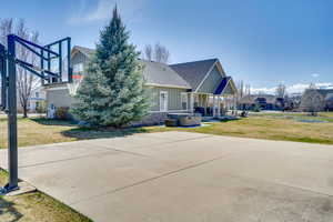 Back of property featuring a yard, roof with shingles, board and batten siding, and cooling unit