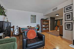 Living area with visible vents, baseboards, and wood finished floors