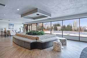 Living area featuring visible vents, a view of city, a textured ceiling, and wood finished floors