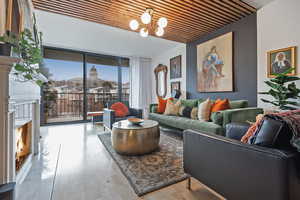 Living area featuring hardwood / wood-style flooring, wood ceiling, a notable chandelier, and a fireplace