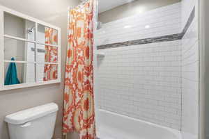 Bathroom with shower / tub combo and toilet