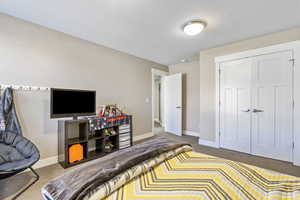 Carpeted bedroom with a closet and baseboards