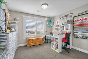 Office space featuring visible vents, carpet flooring, a textured ceiling, and baseboards