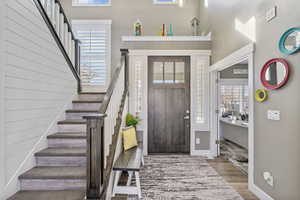 Foyer featuring stairway, baseboards, and wood finished floors