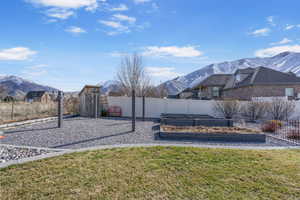 View of yard featuring a mountain view, fence, and a garden