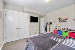 Carpeted bedroom featuring baseboards and a closet