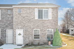 View of front of property with brick siding and roof with shingles