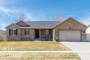 Single story home featuring brick siding, fence, a front yard, driveway, and an attached garage