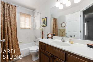 Bathroom featuring vanity, tile patterned floors, toilet, and shower / bath combo with shower curtain