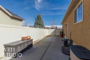 View of patio featuring cooling unit, a fenced backyard, and a gate