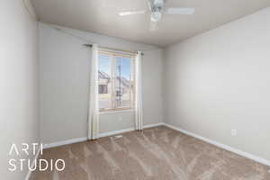 Carpeted empty room with visible vents, baseboards, and a ceiling fan