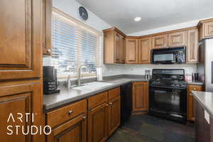 Kitchen featuring brown cabinetry, black appliances, and a sink