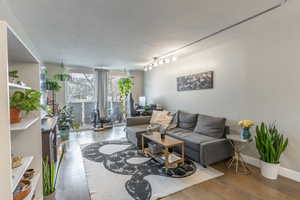 Living area with baseboards and wood finished floors