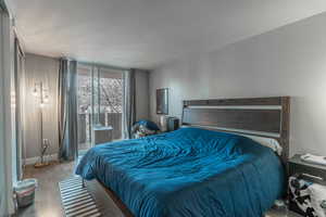 Bedroom featuring access to exterior, wood finished floors, and baseboards