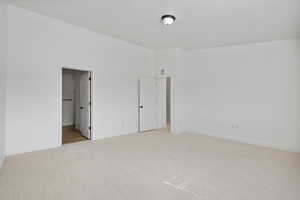 Unfurnished bedroom featuring visible vents, light colored carpet, baseboards, and a textured ceiling