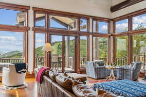 Living area with high vaulted ceiling, wood finished floors, and a mountain view