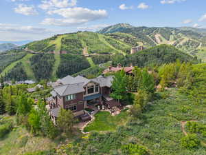 Aerial view of property and surrounding area featuring a mountainous background