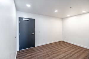 Spare room featuring recessed lighting, baseboards, and dark wood finished floors