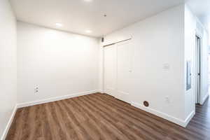 Spare room with visible vents, baseboards, and wood finished floors