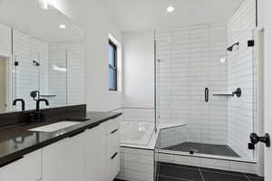 Bathroom featuring a bath, recessed lighting, a shower stall, and vanity