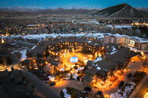 Snowy aerial view featuring a mountain view and a residential view