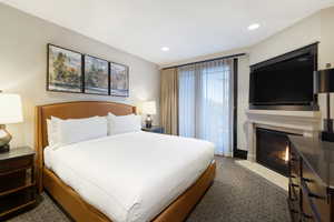 Bedroom with a fireplace with flush hearth, recessed lighting, and carpet