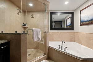 Full bathroom featuring recessed lighting, a jetted tub, a stall shower, and vanity